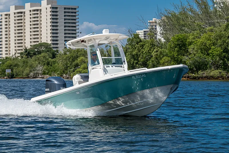 Slide: The Image of 2012 Everglades 243 Center Console boat cruising on water near buildings and trees. - 43