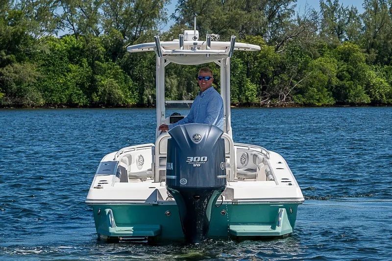 Slide: The Image of Man steering 2012 Everglades 243 Center Console boat on a scenic lake. - 37