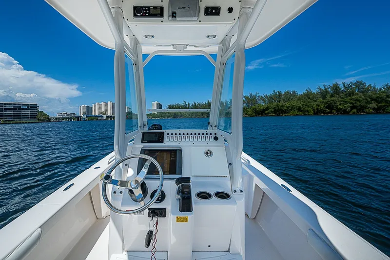 Slide: The Image of 2012 Everglades 243 Center Console boat on water, featuring steering wheel and control panel. - 17