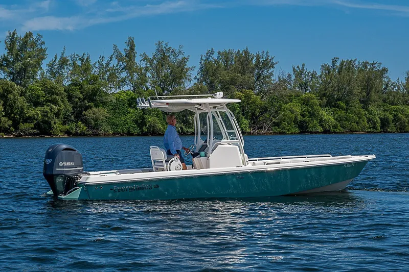 Slide: The Image of 2012 Everglades 243 Center Console boat on water, with lush greenery in the background. - 33