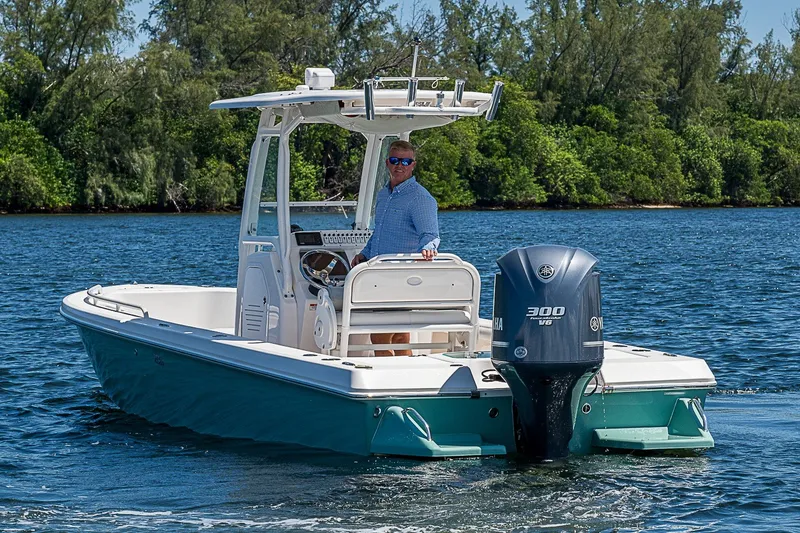 Slide: The Image of 2012 Everglades 243 Center Console boat on water, with lush greenery in the background. - 38