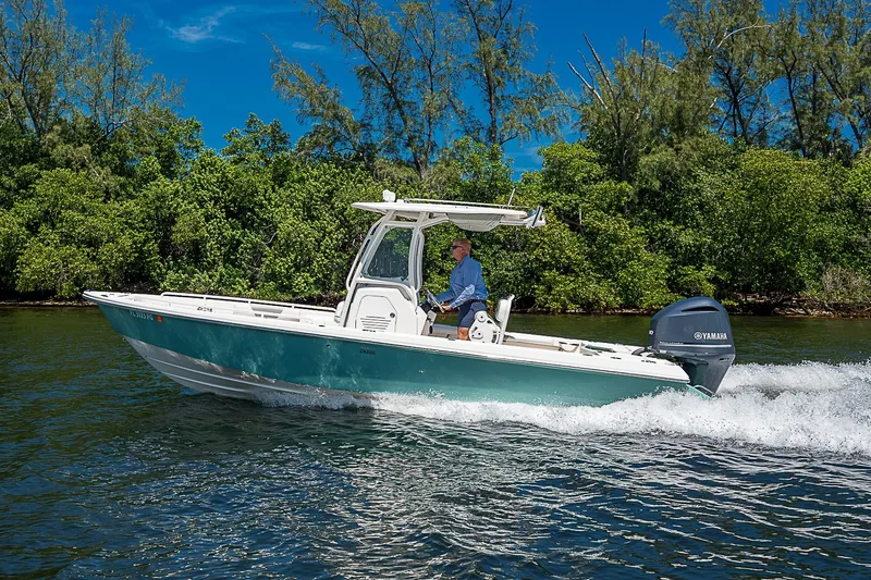 Slide: The Image of 2012 Everglades 243 Center Console boat cruising on water, surrounded by lush greenery. - 57