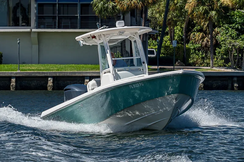 Slide: The Image of 2012 Everglades 243 Center Console boat cruising on water near a waterfront property. - 41