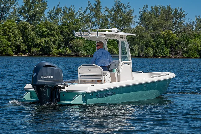 Slide: The Image of 2012 Everglades 243 Center Console boat cruising on a scenic lake with Yamaha engine. - 35