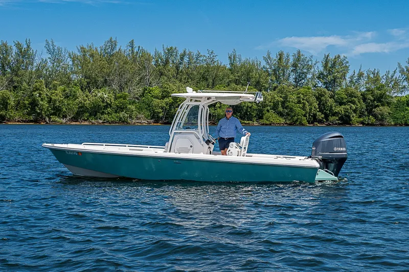 Slide: The Image of 2012 Everglades 243 Center Console boat on water, with lush greenery in the background. - 24