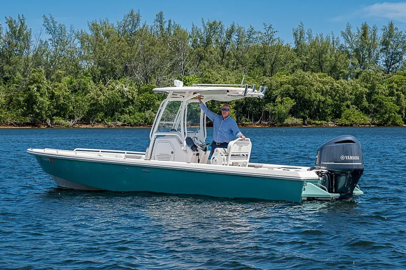 Slide: The Image of 2012 Everglades 243 Center Console boat on water with Yamaha engine, surrounded by trees. - 23