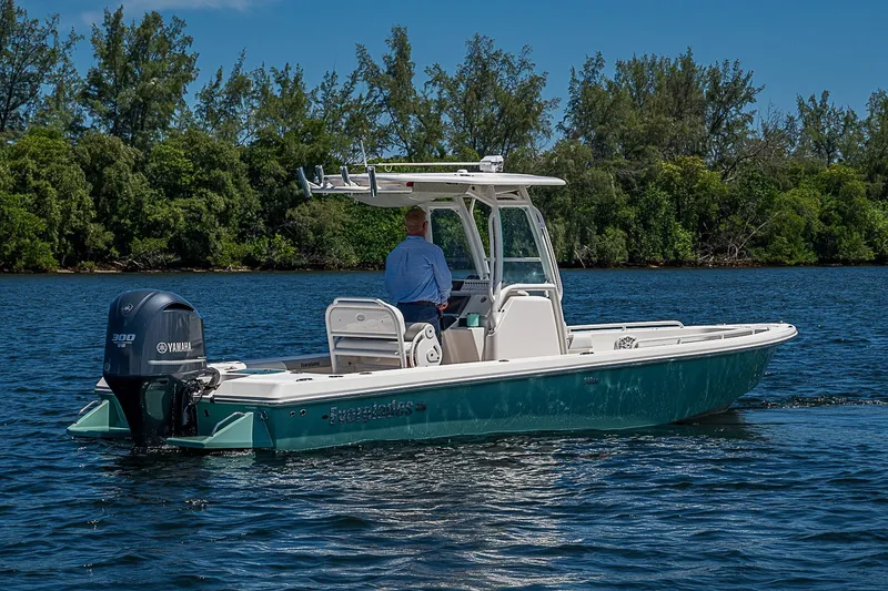 Slide: The Image of 2012 Everglades 243 Center Console boat cruising on a serene lake with lush greenery. - 34