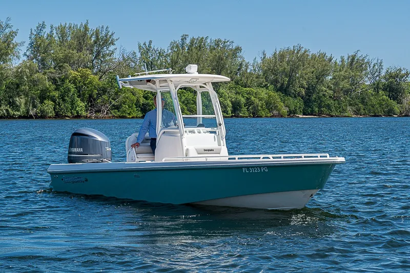 Slide: The Image of 2012 Everglades 243 Center Console boat on water, with Yamaha engine, near lush shoreline. - 30