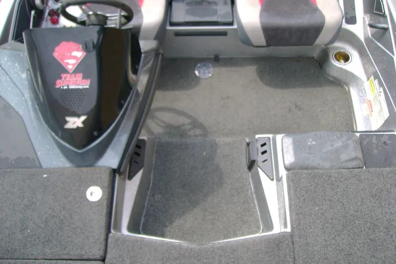 Slide: The Image of 2016 Skeeter ZX225 boat interior with carpeted flooring and seating area. - 10