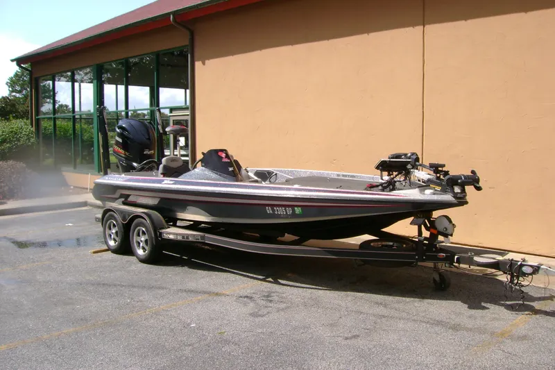 Slide: The Image of 2016 Skeeter ZX225 bass boat parked on a trailer near a building. - 4