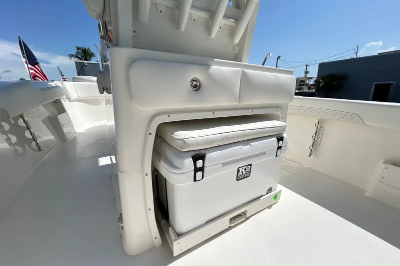 Slide: The Image of 2026 Key West 249 FS boat interior with built-in cooler and seating under sunny sky. - 2
