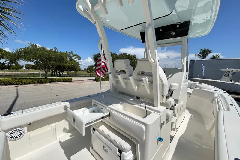 Slide: The Image of 2026 Key West 249 FS boat interior with seating and storage, docked under clear skies. - 17