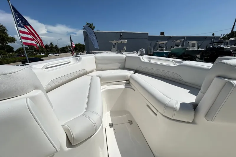 Slide: The Image of 2026 Key West 249 FS boat interior with white seating, American flags in the background. - 6