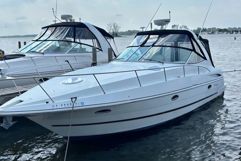 The Image of 2001 Cruisers Yachts 3470 Express docked on calm water. - 1