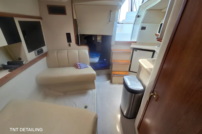 Slide: The Image of Interior of 2001 Cruisers Yachts 3470 Express, featuring seating, stairs, and kitchenette. - 14