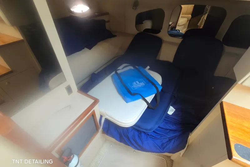 Slide: The Image of Interior of 2001 Cruisers Yachts 3470 Express, featuring cozy seating and a compact table. - 15