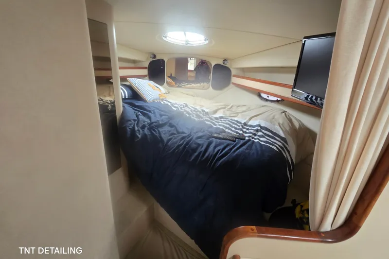 Slide: The Image of Cozy cabin interior of 2001 Cruisers Yachts 3470 Express with bed and TV. - 11