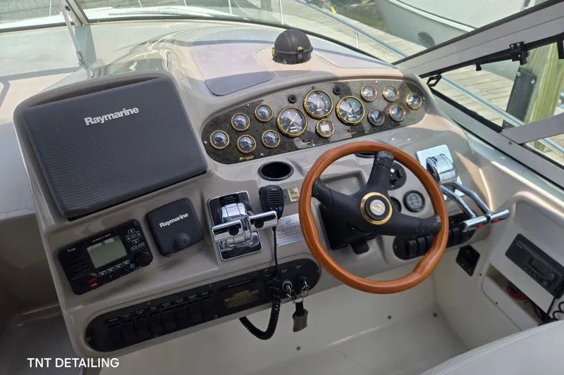 Slide: The Image of 2001 Cruisers Yachts 3470 Express helm with Raymarine electronics and wooden steering wheel. - 6