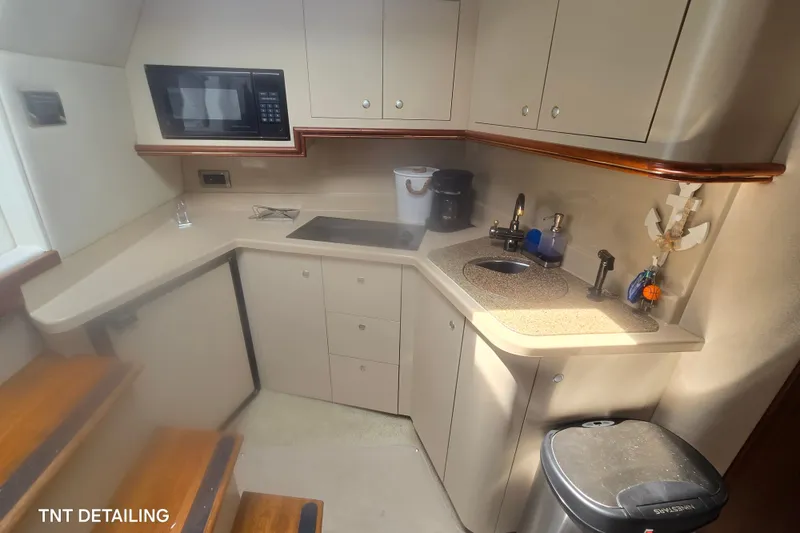 Slide: The Image of 2001 Cruisers Yachts 3470 Express galley with microwave, sink, and storage cabinets. - 9