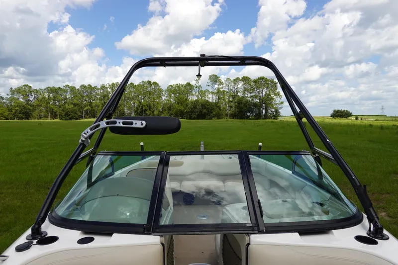 Slide: The Image of 2000 Malibu Wakesetter 23 LSV boat with tower, parked on grassy field under cloudy sky. - 15