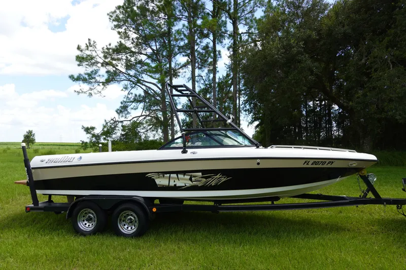 Slide: The Image of 2000 Malibu Wakesetter 23 LSV boat on trailer, parked on grassy field. - 3