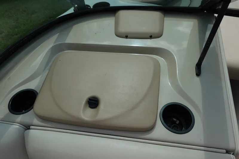 Slide: The Image of 2000 Malibu Wakesetter 23 LSV boat dashboard with cup holders and storage compartment. - 14