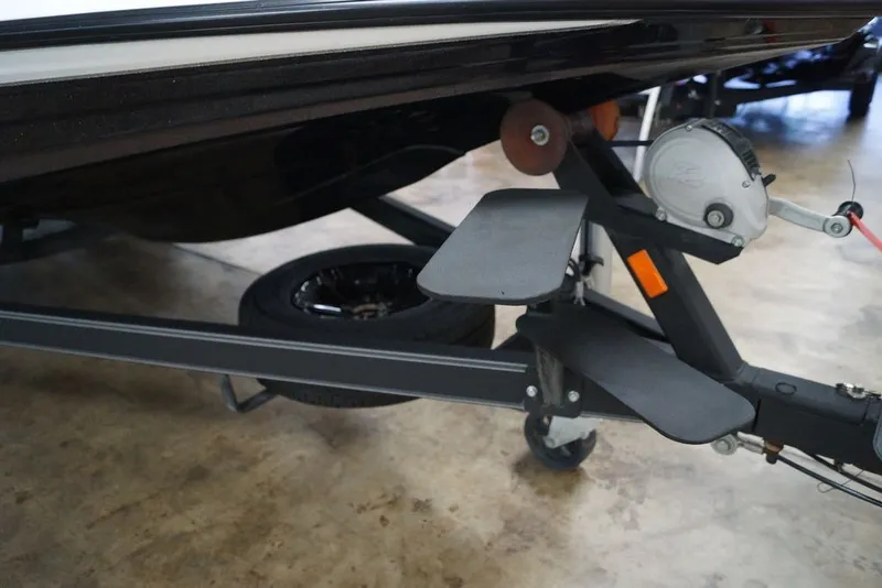 Slide: The Image of 2023 Skeeter ZXR21 boat trailer with winch and step pads in a showroom. - 6