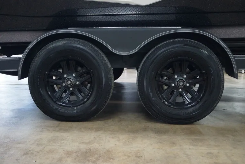 Slide: The Image of 2023 Skeeter ZXR21 trailer with dual black wheels on a concrete floor. - 4
