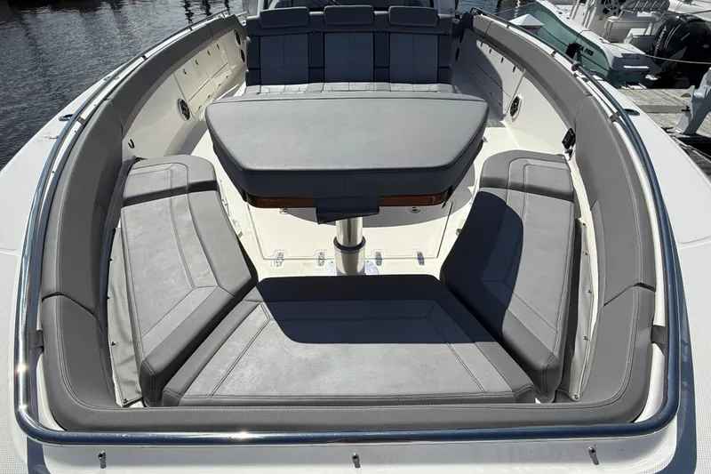 Slide: The Image of 2024 Boston Whaler 420 Outrage boat interior with gray seating and central table. - 51
