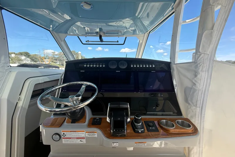Slide: The Image of 2024 Boston Whaler 420 Outrage helm with modern controls and panoramic view. - 34