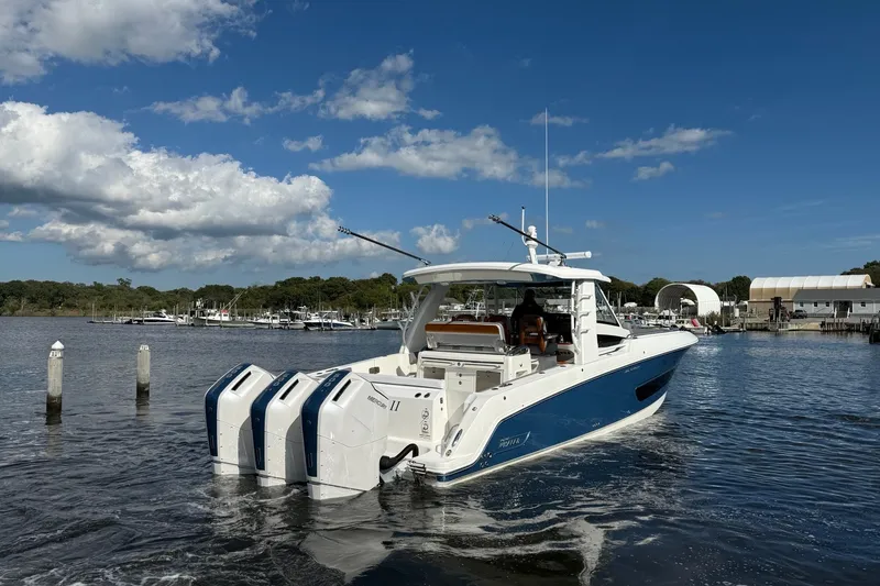 Slide: The Image of 2024 Boston Whaler 420 Outrage boat with triple engines on a sunny day. - 6