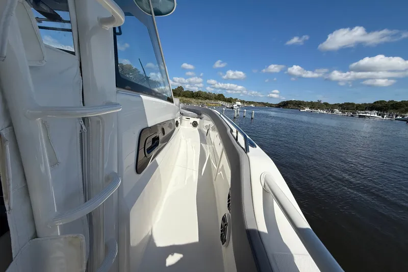 Slide: The Image of 2024 Boston Whaler 420 Outrage boat on calm water under a clear blue sky. - 45