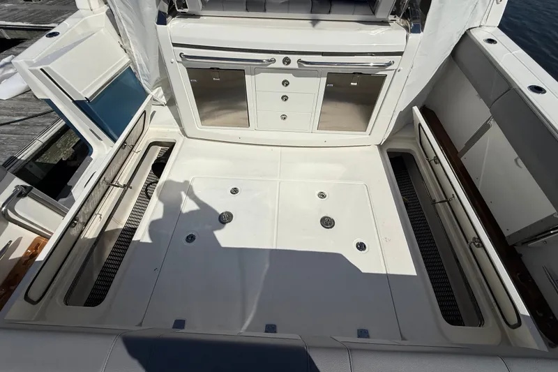 Slide: The Image of 2024 Boston Whaler 420 Outrage deck with storage compartments and sleek cabinetry. - 21