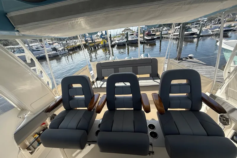 Slide: The Image of 2024 Boston Whaler 420 Outrage interior with luxurious seating at a marina. - 29