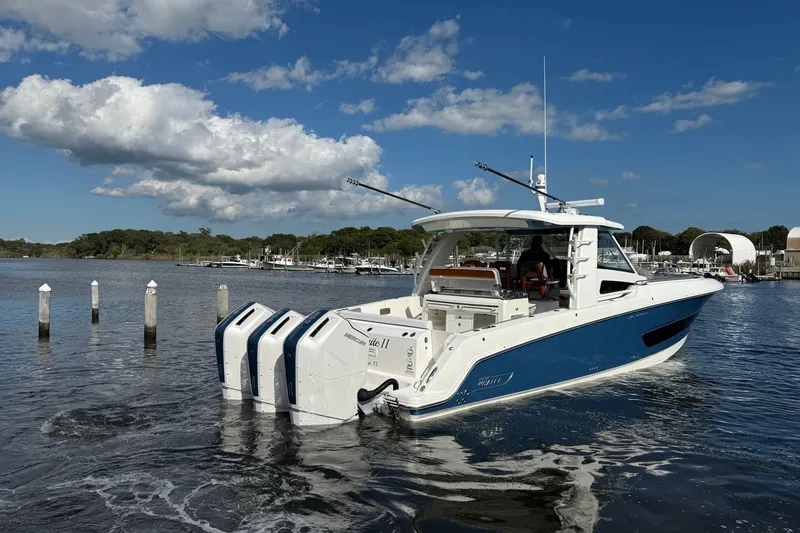 Slide: The Image of 2024 Boston Whaler 420 Outrage boat on water, featuring triple engines and sleek design. - 3