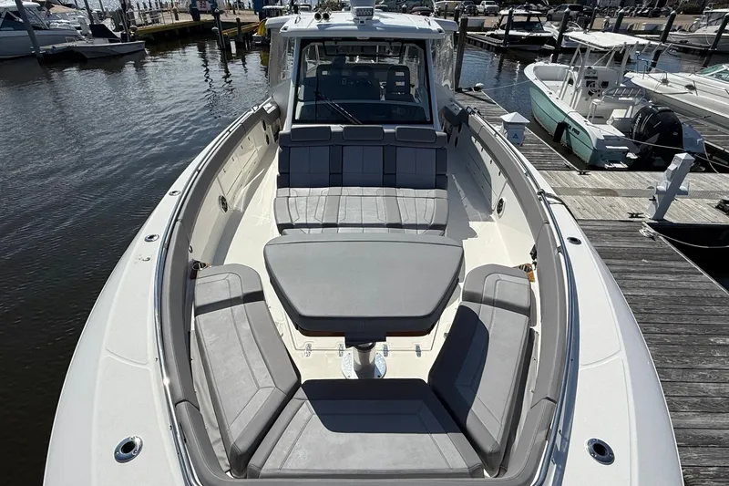 Slide: The Image of 2024 Boston Whaler 420 Outrage boat with spacious seating at a marina dock. - 48