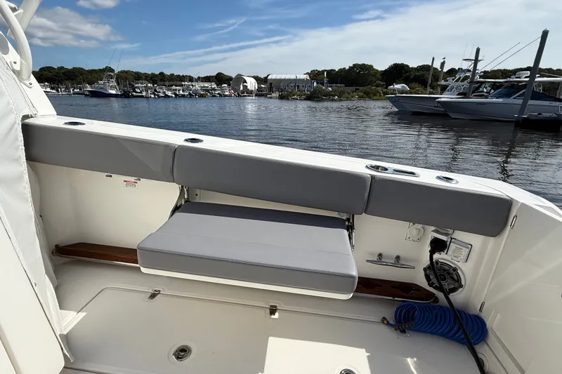 Slide: The Image of 2024 Boston Whaler 420 Outrage boat interior with seating and marina view. - 20