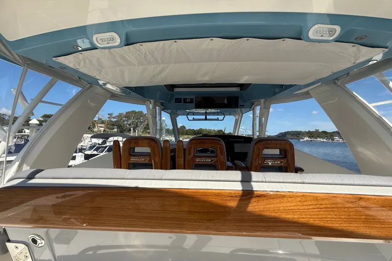 Slide: The Image of Interior view of 2024 Boston Whaler 420 Outrage boat, featuring luxurious seating and wood accents. - 26
