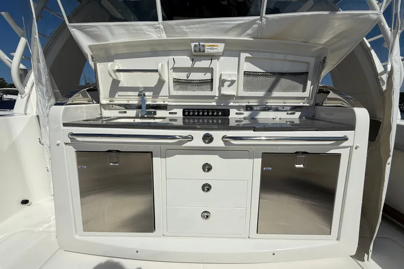 Slide: The Image of 2024 Boston Whaler 420 Outrage boat galley with stainless steel appliances and storage compartments. - 23