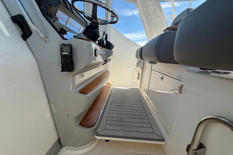 Slide: The Image of 2024 Boston Whaler 420 Outrage helm area with steering wheel and seating. - 32