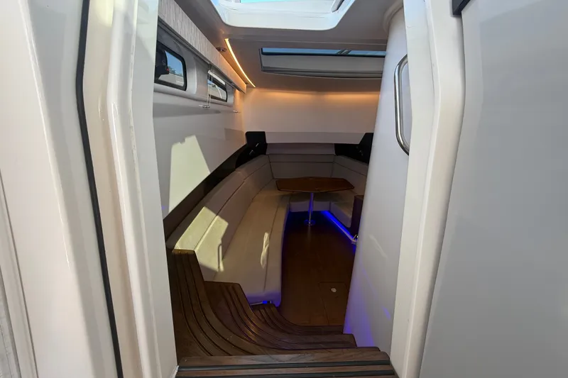 Slide: The Image of Interior cabin of 2024 Boston Whaler 420 Outrage with modern seating and ambient lighting. - 35