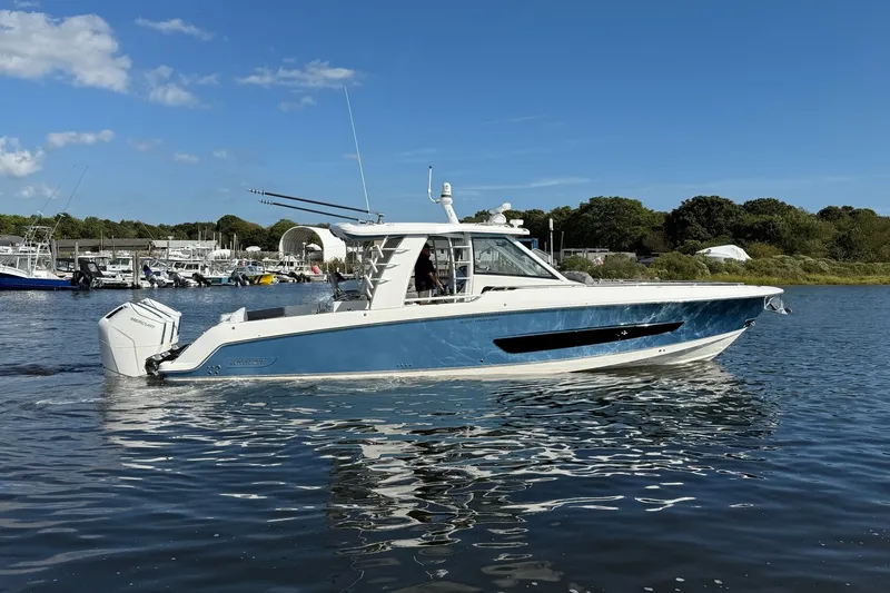 Slide: The Image of 2024 Boston Whaler 420 Outrage boat on calm water, clear sky background. - 4