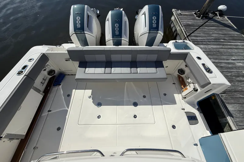 Slide: The Image of 2024 Boston Whaler 420 Outrage boat deck with triple engines and seating area. - 15