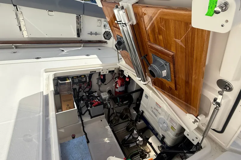Slide: The Image of 2024 Boston Whaler 420 Outrage engine compartment with equipment and wooden panel. - 13