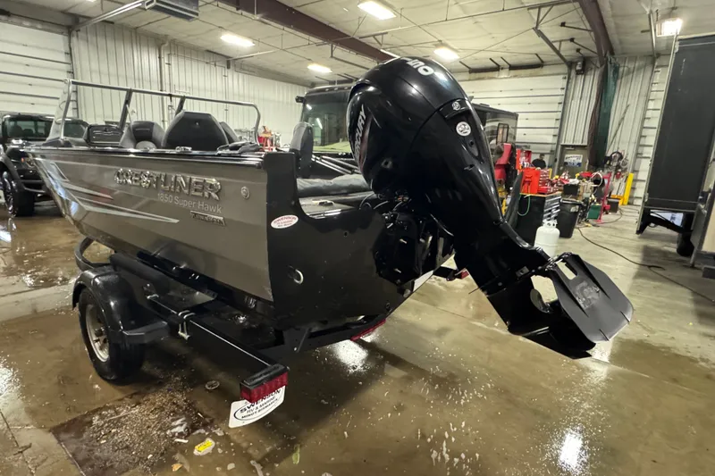 Slide: The Image of 2020 Crestliner 1850 Super Hawk boat with outboard motor in a garage setting. - 4
