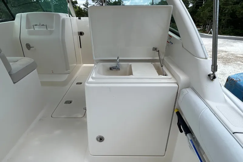Slide: The Image of 2012 Pursuit DC 265 Dual Console boat interior with open sink compartment. - 12