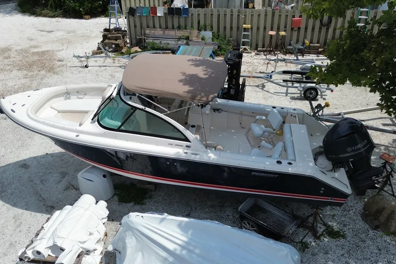 Slide: The Image of 2012 Pursuit DC 265 Dual Console boat with Yamaha engine, parked on gravel. - 26