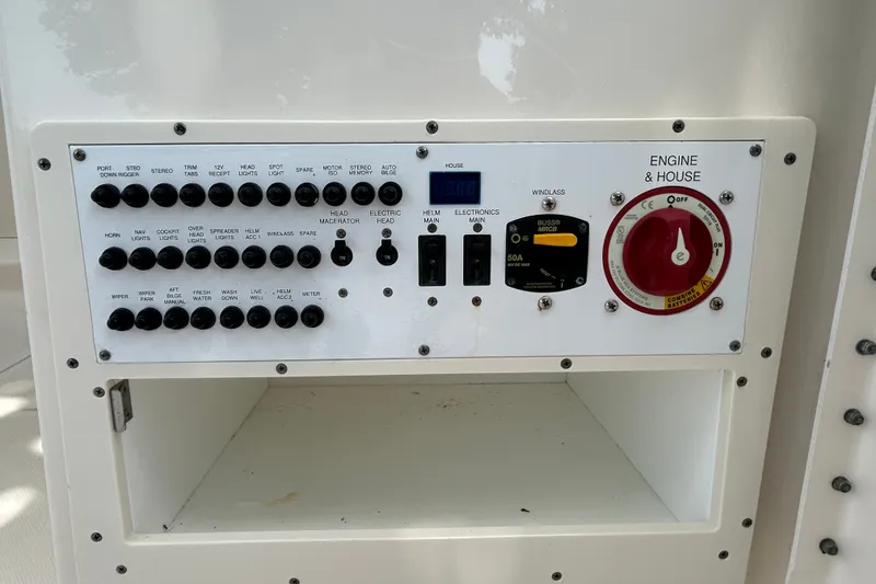 Slide: The Image of Control panel of a 2012 Pursuit DC 265 Dual Console boat, featuring various switches and dials. - 14