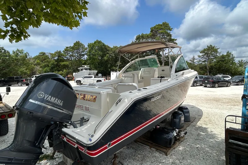 Slide: The Image of 2012 Pursuit DC 265 Dual Console boat with Yamaha engine in a parking area. - 7