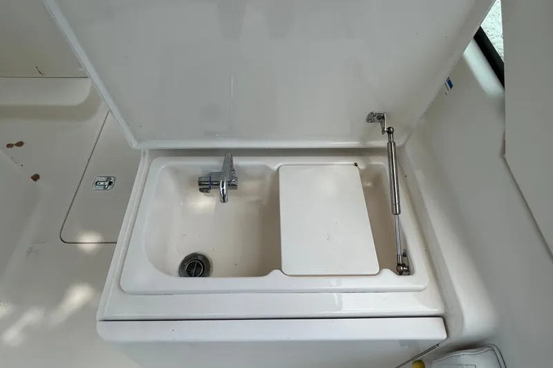 Slide: The Image of 2012 Pursuit DC 265 Dual Console boat sink with faucet and cover. - 13